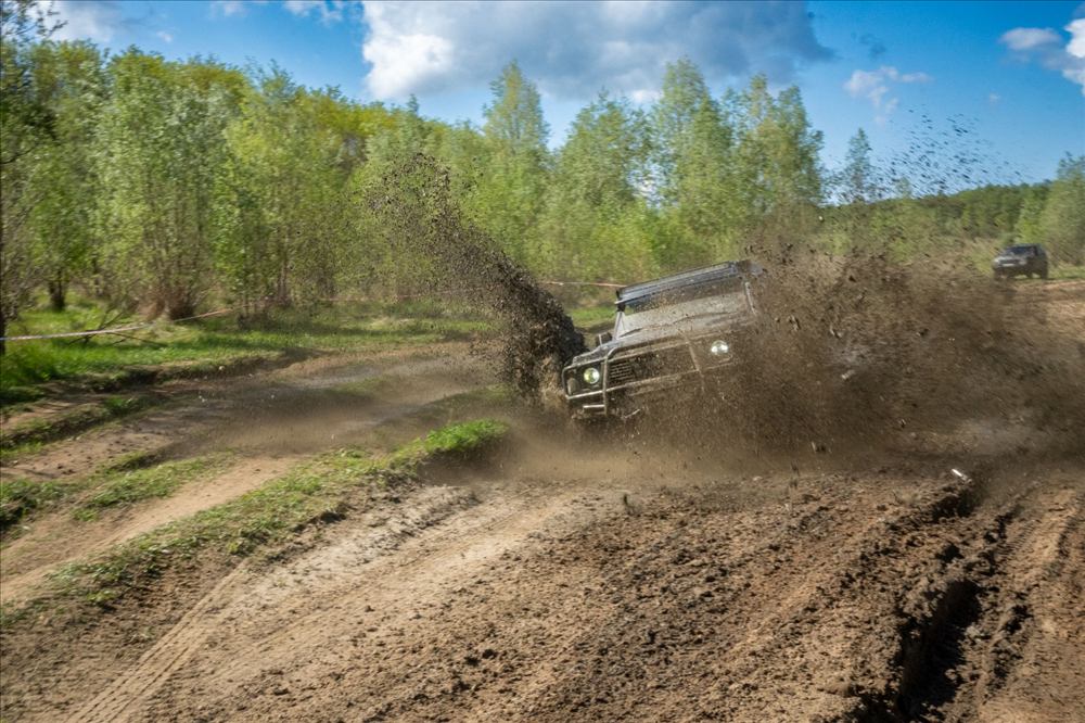 Nissan Patrol wyrzucający ścianę błota na trasie