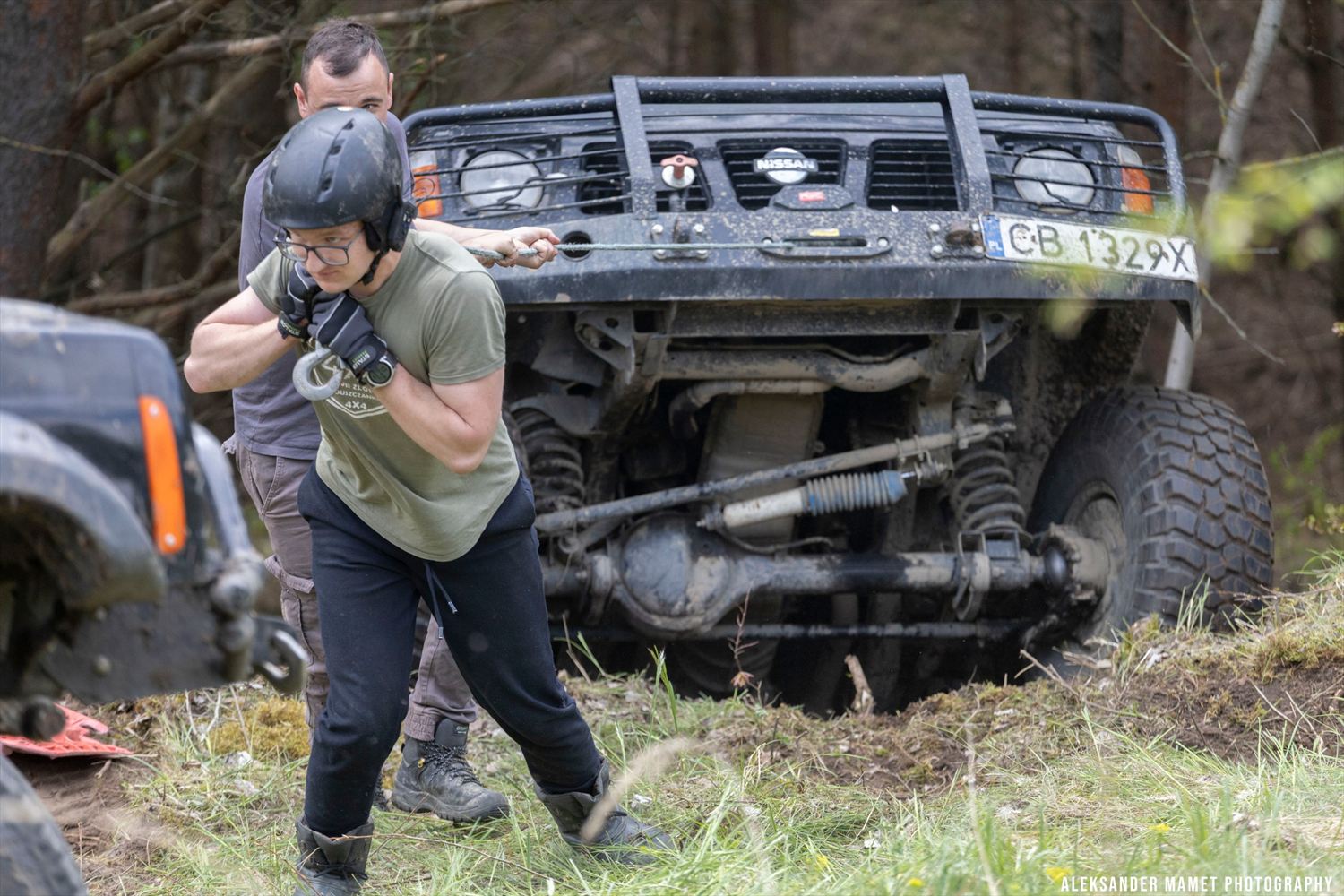 Załoga ciągnąca linę wyciągarki do zakopanego auta